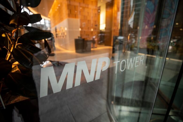 A photo of an office building window, with text reading 'MNP Tower'.