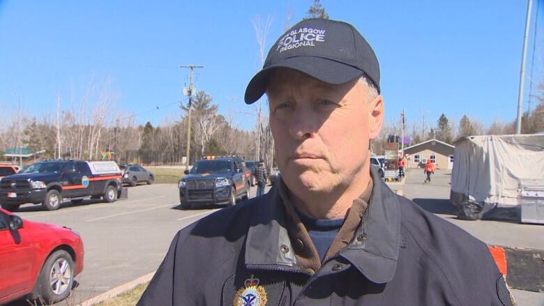 A police officer stands in a parking lot.