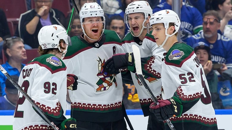 An Arizona Coyotes player stands with three teammates after scoring a goal against the Canucks during an April 10, 2024 NHL game at Rogers Arena in Vancouver.