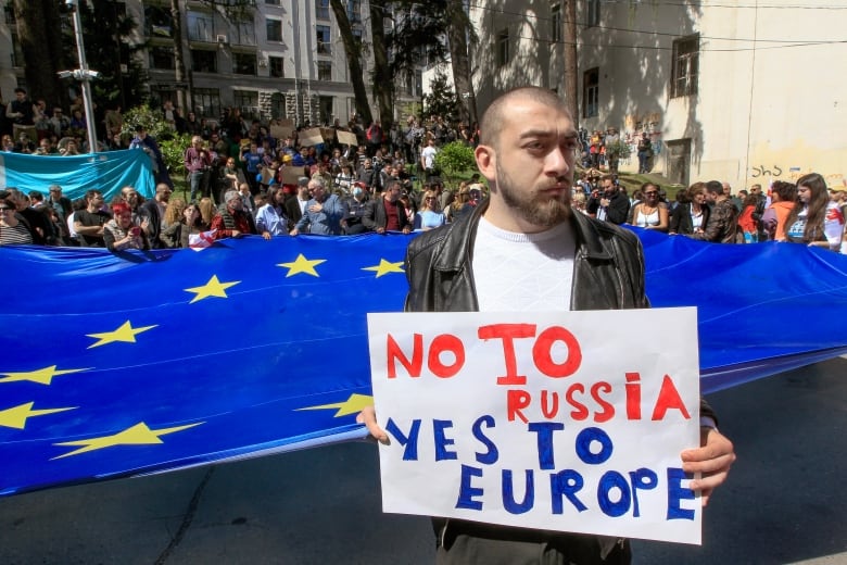 A man holds a sign that says 