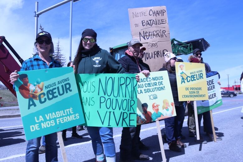 A group of people holding up signs on the side of the street.