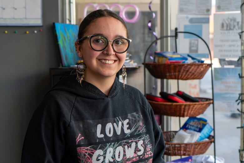 A person wearing glasses and a hoodie that says 