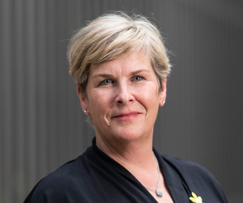 Jane Parsons, Executive Vice President, Revenue Development, Executive Office and Community Giving at the Canadian Cancer Society wears a black shirt with a yellow daffodil pin. 