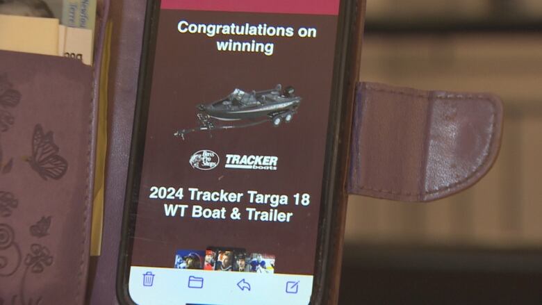 A smartphone screen shows a picture of a boat and trailer.