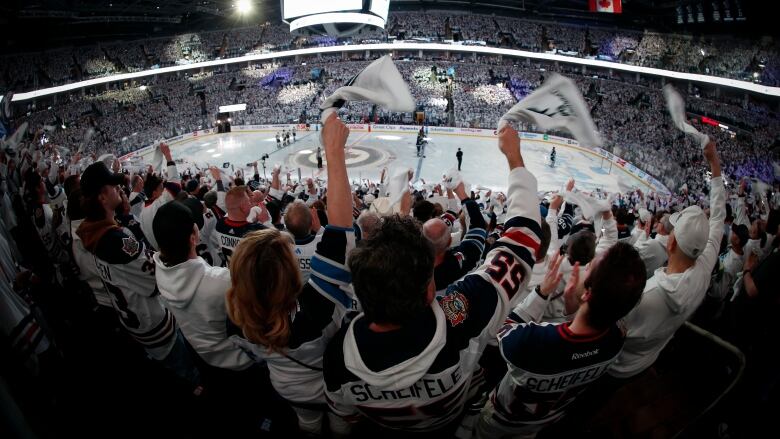 Winnipeg Jets fans swing white towels at a playoff game. 