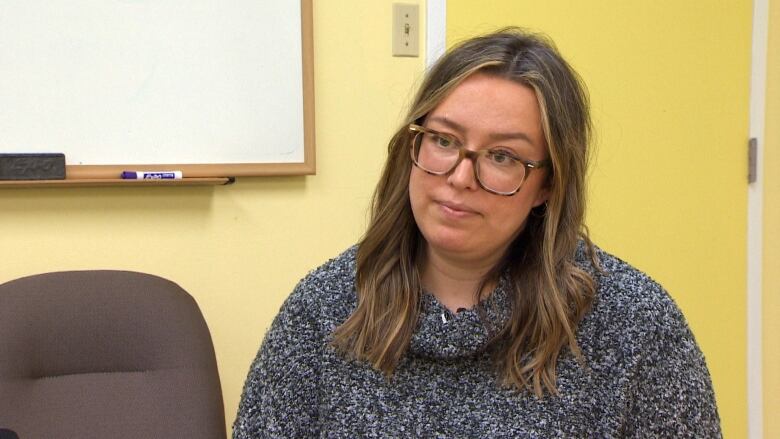 A woman speaks to a reporter