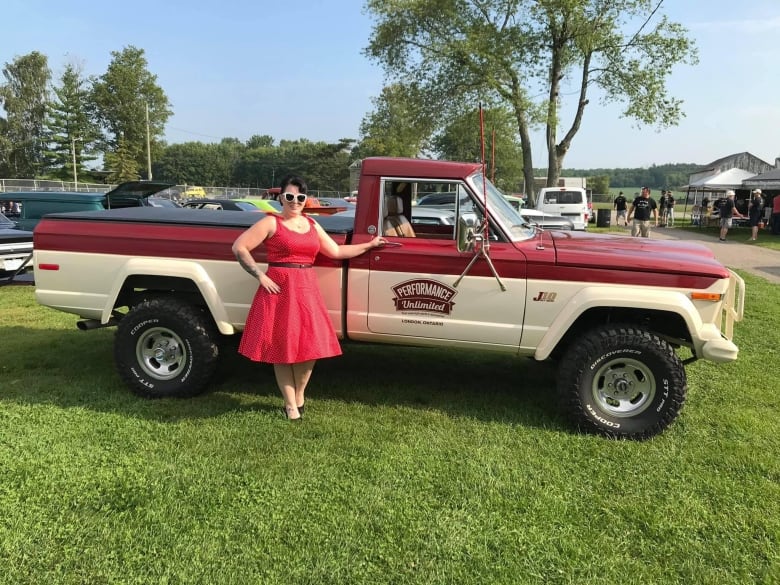 a woman posing with a pickup truck