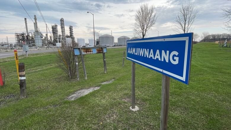 sign with chemical plant in the background