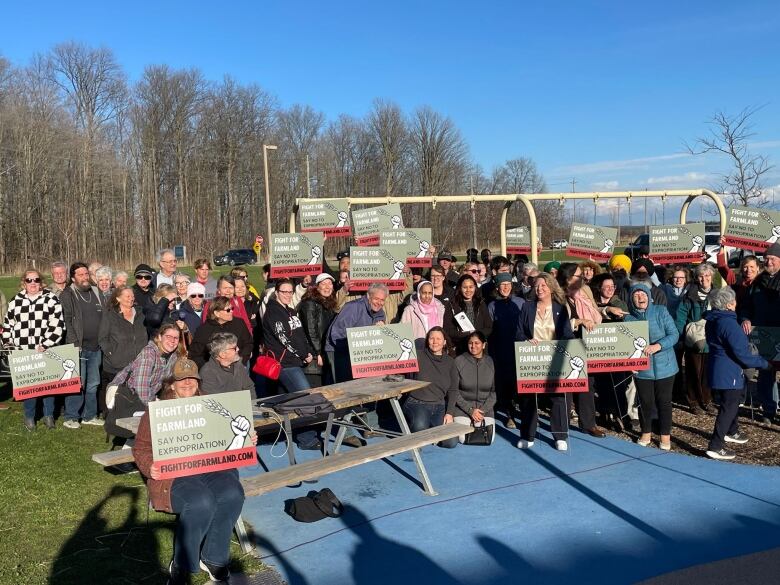 A group of people outside posing with signs. 