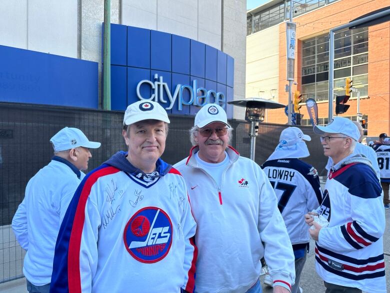 Two people wearing Jets jerseys