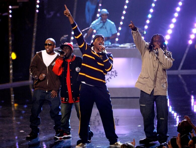 Rappers gesture while performing onstage.