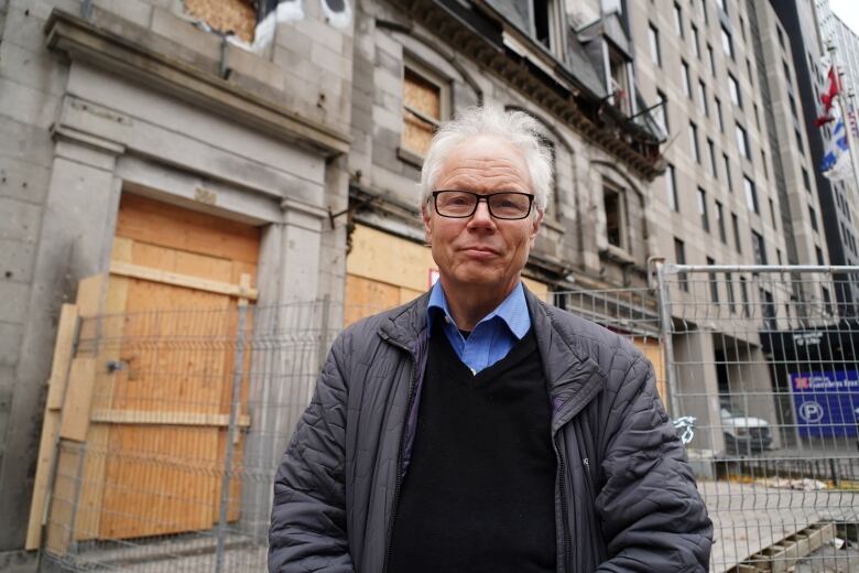 man in front of a boarded up building