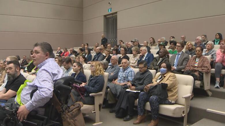 a room full of people sitting in rows.