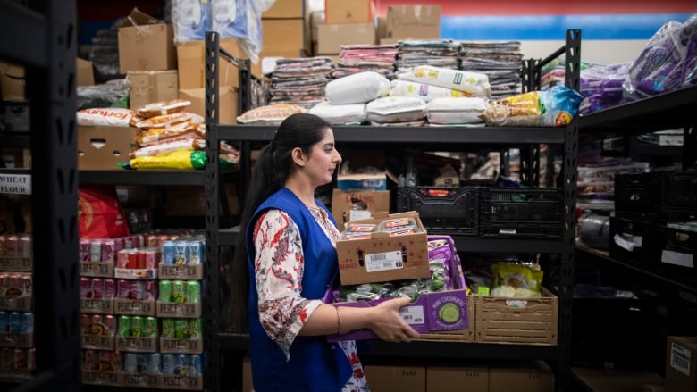 Volunteers pack groceries for people in need  at the Guru Nanak Food Bank in Delta, B.C on Friday April 19, 2024.  