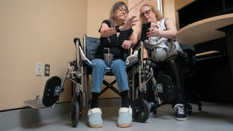 Two women look at cell phone