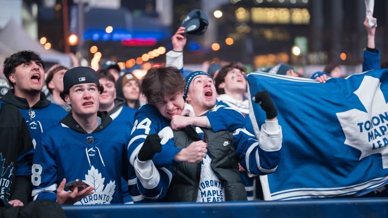 A group of fans watching The Leafs on screen outside Scotiabank Arena.