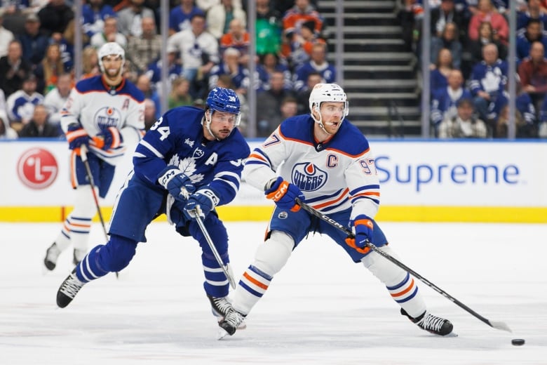 A hockey player backchecks against an opponent.