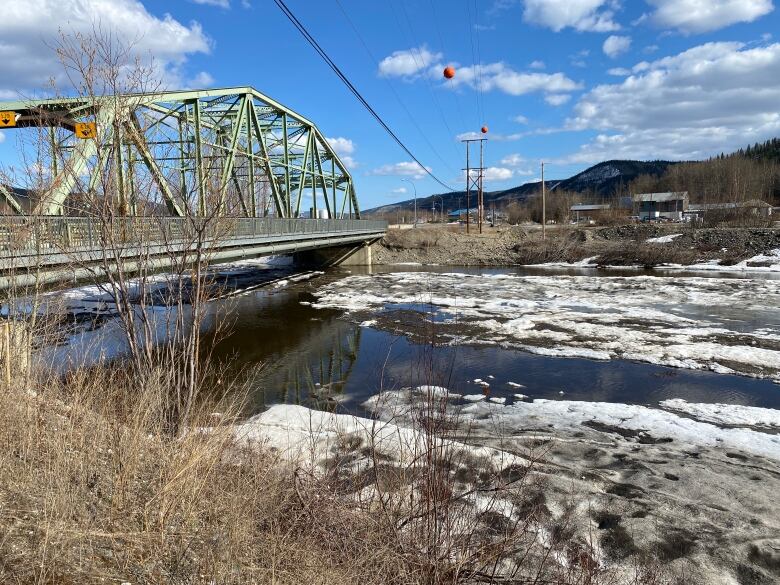 A highway bridge is seen over an ice-filled river.