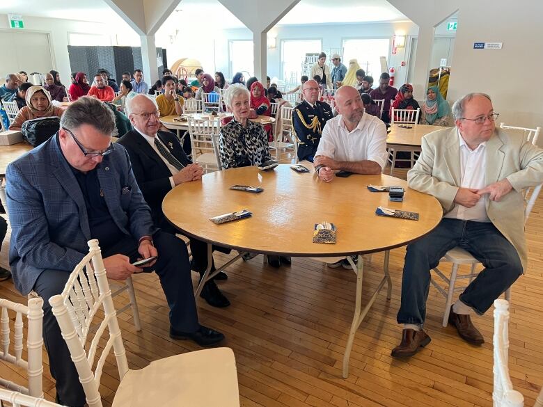 A group of dignitaries sit around a table.