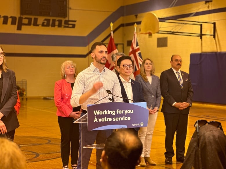 People stand in front of podium that reads 