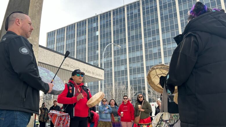 People drumming in front of a crowd