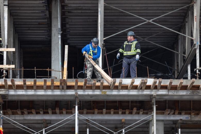 Two men are shown on a worksite. 