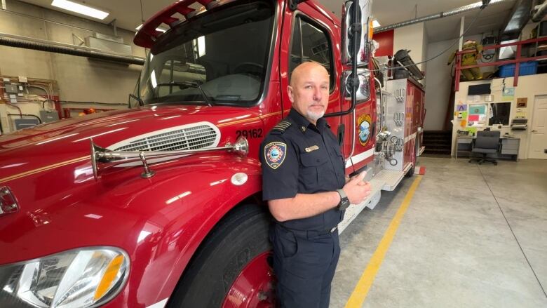 A man stands next to a firetruck