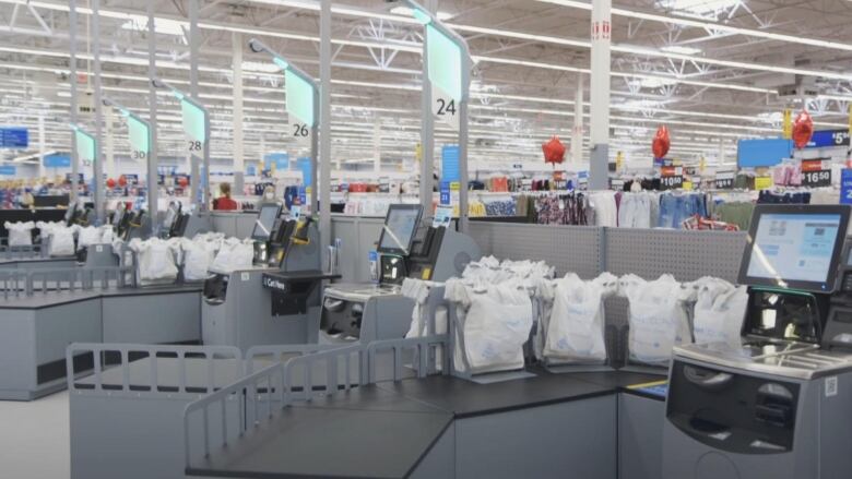 A line-up of self-checkouts in a Walmart store. 