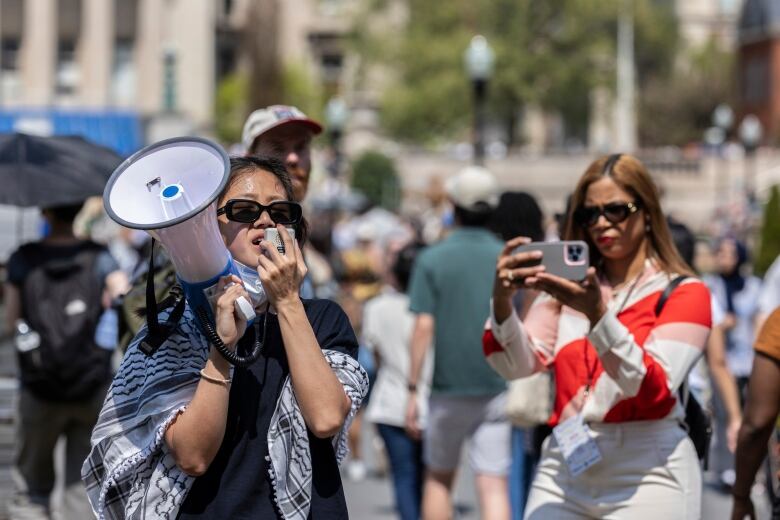 A student protester yells into a megaphone at an encampment on the campus of Columbia University, in New York, on Monday.