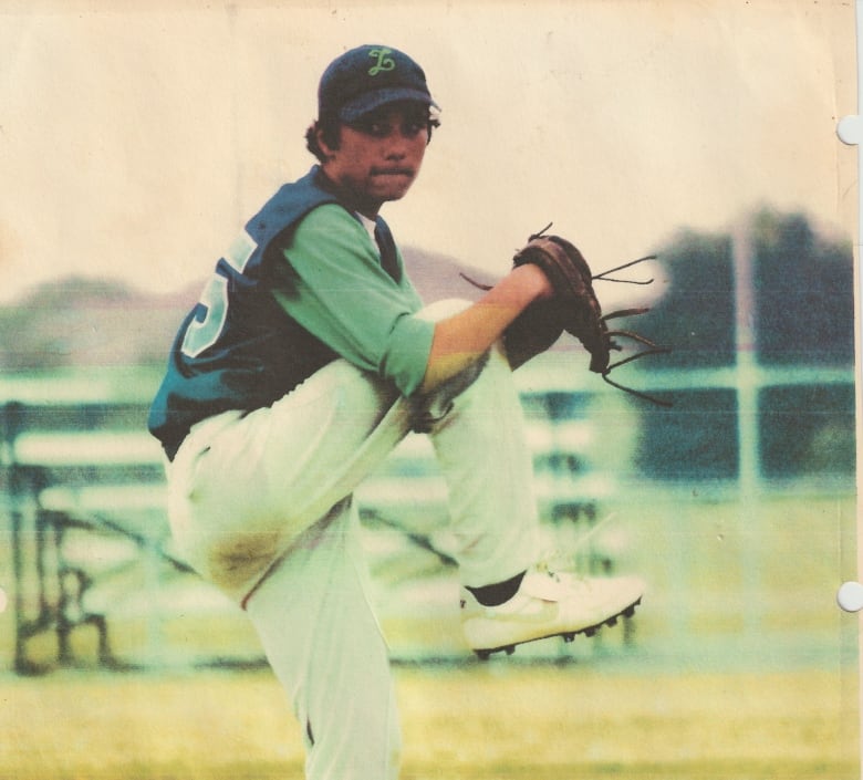 A teen pitching a baseball.