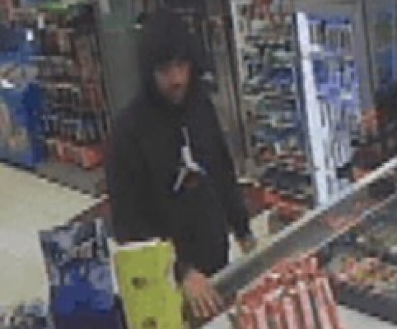 A man is shown in surveillance footage in what appears to be a convenience store.