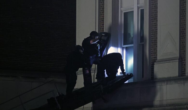 NYPD officers in riot gear break into a building at Columbia University, where pro-Palestinian students are barricaded inside a building and have set up an encampment, in New York City on April 30, 2024.