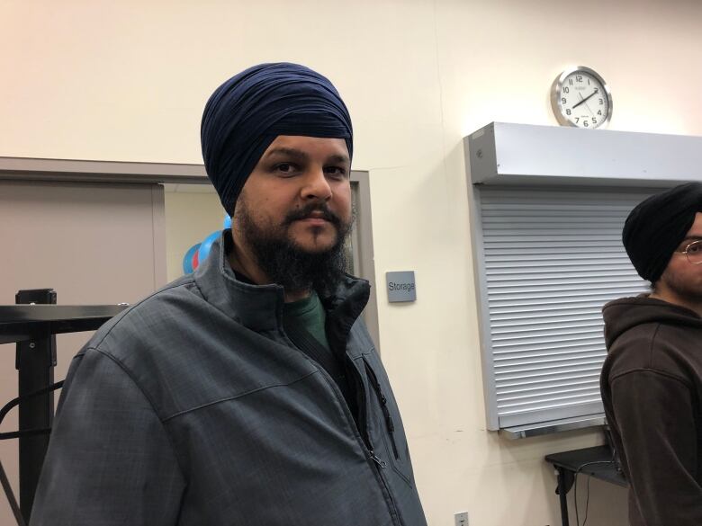 A South Asian man wearing a turban smiles.