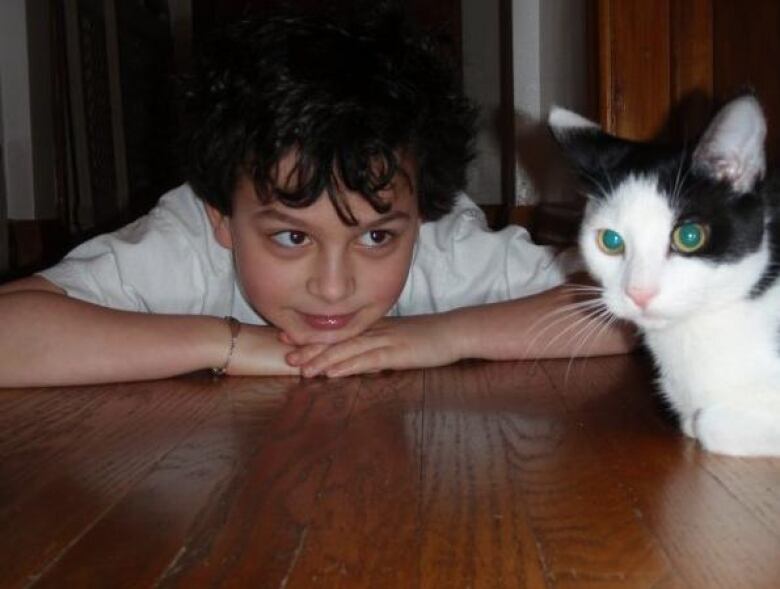 Eight-year-old Keith de Silvia-Legault with childhood tuxedo cat, 