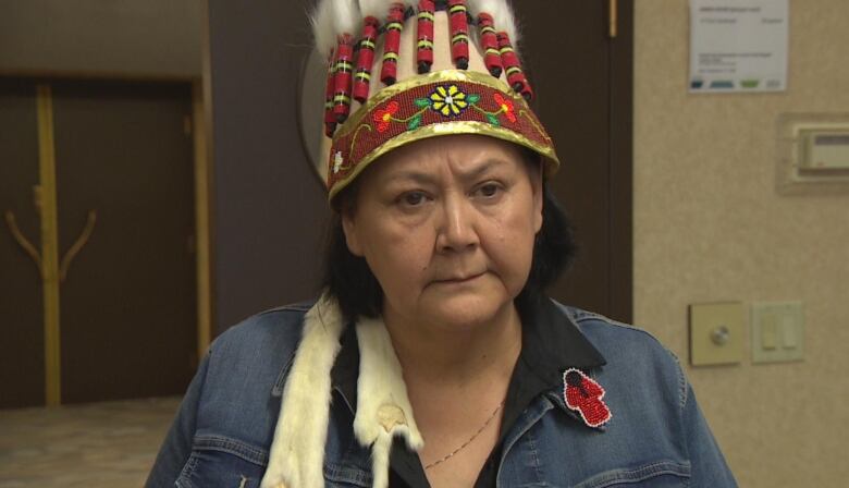 A woman wearing a headdress looks forward.