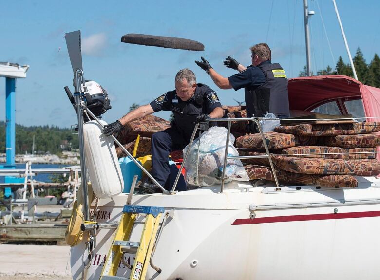 Canada Border Services Agency officers remove waterlogged material from the sailboat Quesera at East River Marine in Hubbards, N.S., on Friday, Sept. 8, 2017. Approximately 273 kilograms of suspected cocaine were found on the vessel and two men were arrested.