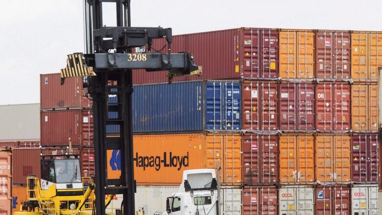 Containers are unloaded at the Port of Montreal in Montreal on July 20, 2017. The Canada Border Services Agency and the Port of Montreal are dipping their feet into a blockchain-powered technology that aims to streamline freight shipping and cut costs. In a trial run, the federal customs agency and the country's second-biggest port have signed on to the digital database -- a distributed ledger that shares and syncs up data from carriers, ports and wholesalers in places from Singapore to Peru. 