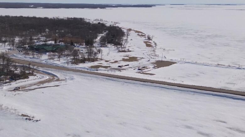 An aerial photo shows a bridge and road running through a community in the winter.