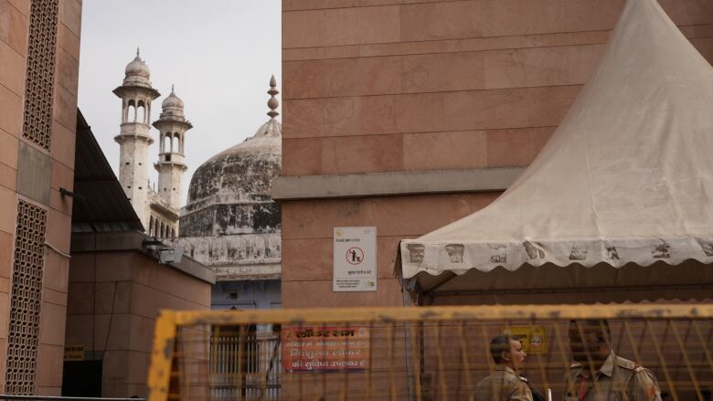 Security guards and fences surround a mosque.