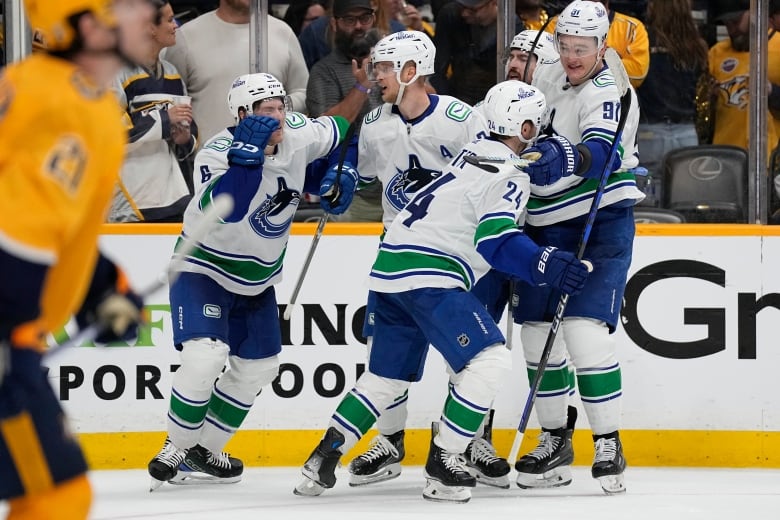 Hockey players celebrate on the ice.