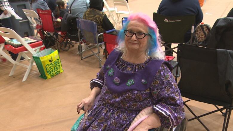 A woman in a wheelchair smiles for a photo.