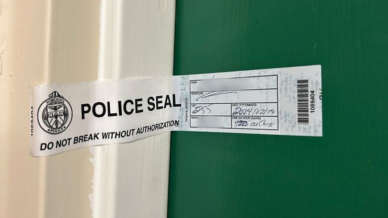 A sticker that goes across the opening of a door reads: police seal. Do not break without authorization. 