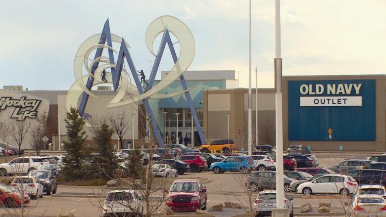 A mall is pictured with a half-full parking lot.