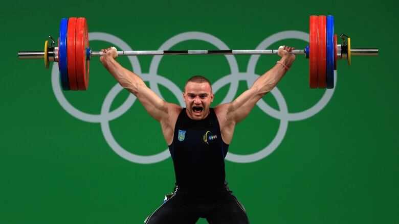 A weightlifter competes at the Olympics.