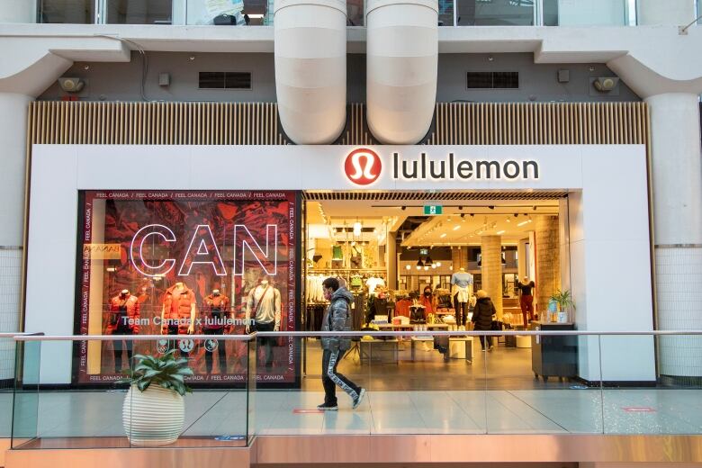 A person walks by a Lululemon clothing store in a shopping mall.