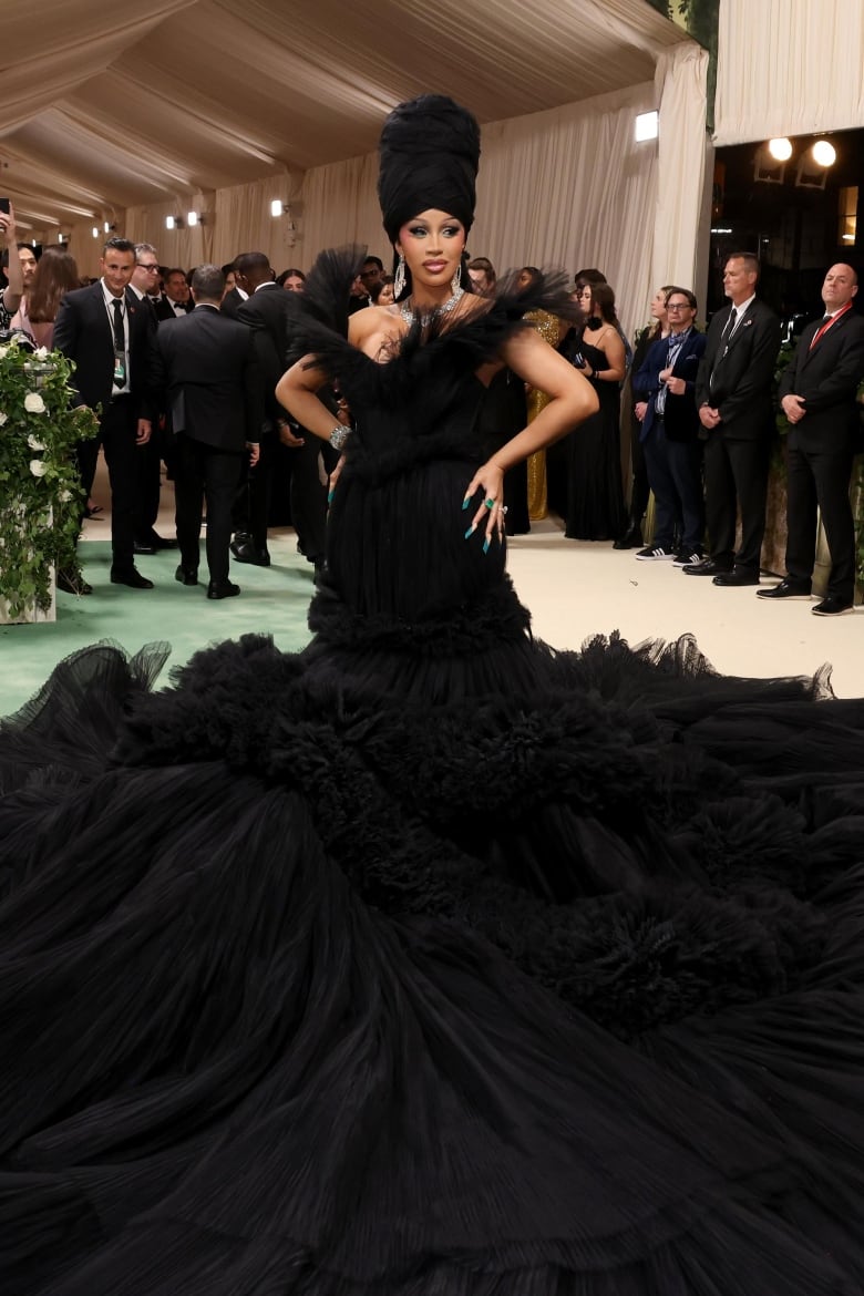 Cardi B on the Met Gala red carpet wearing a strapless black tulle dress with a dramatic train.