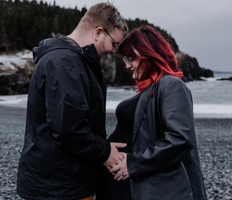 A pregnant couple on a beach