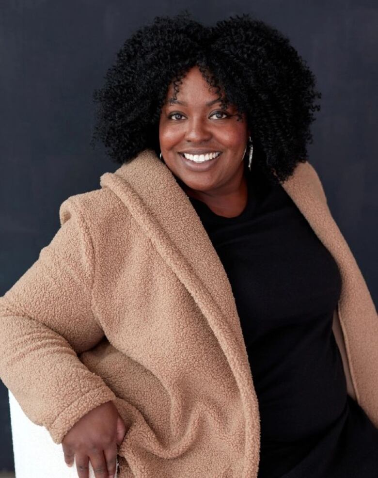 A woman's headshot, sitting in a chair.