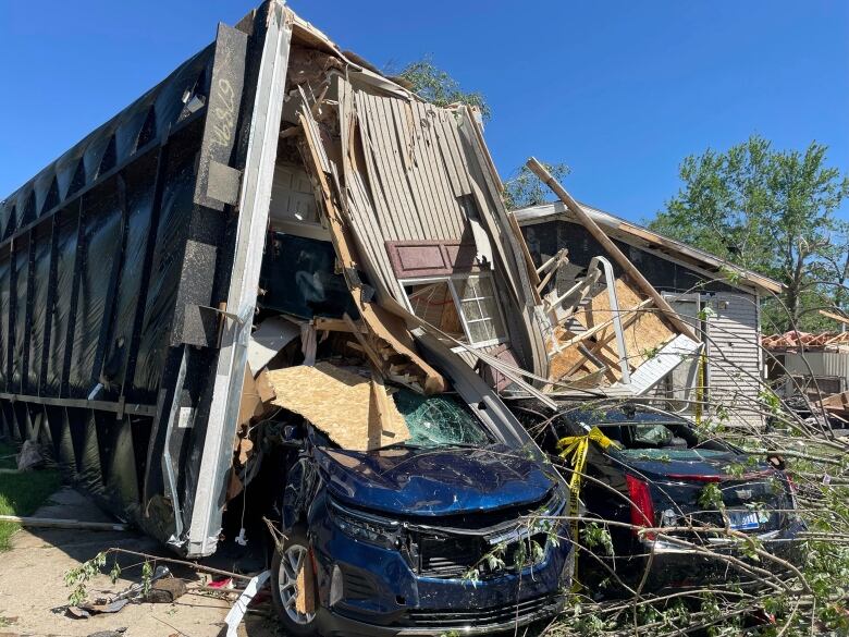 A mobile home is seen after it toppled onto cars at a mobile home park near Kalamazoo, Mich.