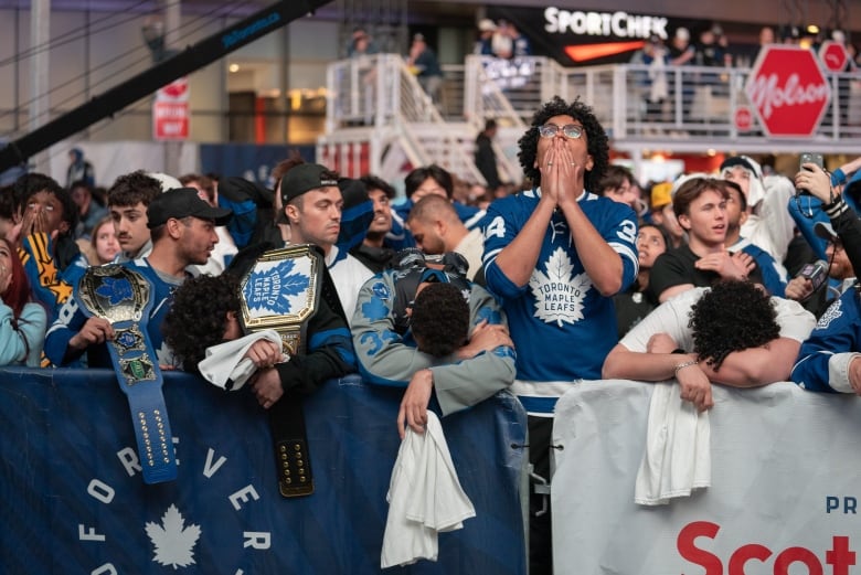 Fans at a tailgate party outside Scotiabank Arena, reacting in disappointment and disbelief after Toronto Maple Leafs eliminated from first round of the NHL Playoffs.